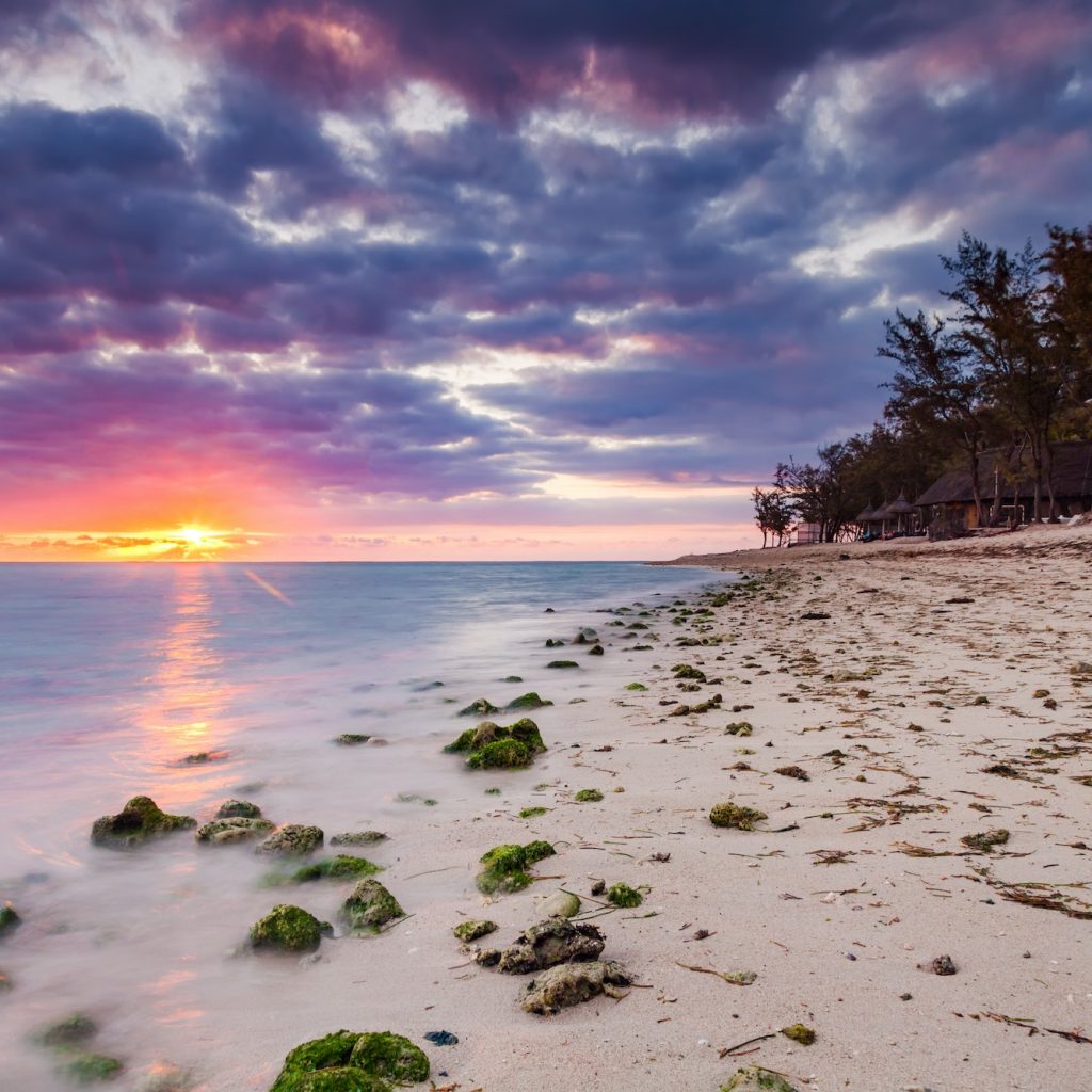 Beautiful sunset on the beach in a tropical resort at Reunion island.