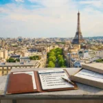 Check liste déménagement sur un toit avec vue sur Paris: carnet et liste de contrôle à cocher, proximité de l’Eiffel.